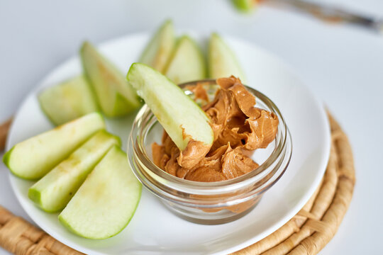 Green slices apples with peanut butter on white background, healthy snack, nutrition food, diet