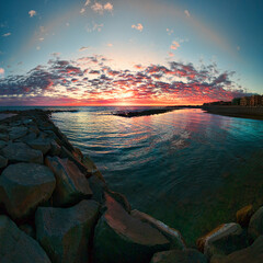 Fantastic sunset on the Roman coast with sky painted with hues of pink, orange, and purple clouds,...