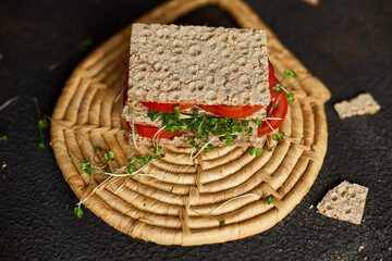 Healthy vegan sandwich with crisp rye bread tomatoe and microgreens