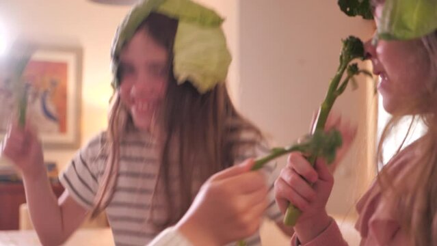 Girls playing with cabbages and broccoli