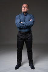 Pensive mature businessman on gray