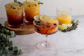 Fresh cocktails with ice, orange juice and grenadine syrup decorated with berries close-up