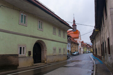 The historic Spodnji Trg Street in Skofja Loka in Gorenjska, Slovenia. Zalostna Mati Bozja v Spitalski Cerkvi - the Sorrowful Mother of God in Spital church - can be seen in the background
