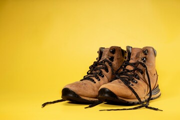 Hiking boots made of leather isolated yellow background
