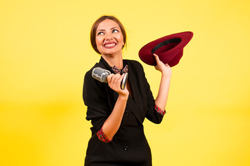 girl in a black suit on a yellow background sings in a retro microphone, portrait, music