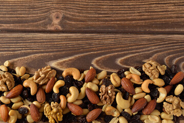 Nuts mixture of almond, cashew, peanut and raisin free-space view on wooden table 