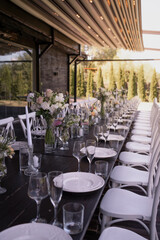 A very nicely decorated wedding table appointments with beautiful decor with plates and serviettes in spring garden. Beautiful flowers on table in wedding day. The elegant dinner table.