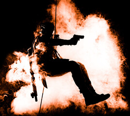 Silhouette of police officer in tactical gear descending from a height, rope exercises with...