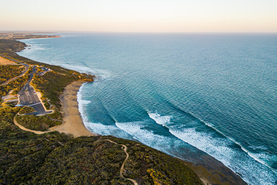 An aerial view of waves hitting Bells Beach at sunset in Torquay, Victoria, Australia. 