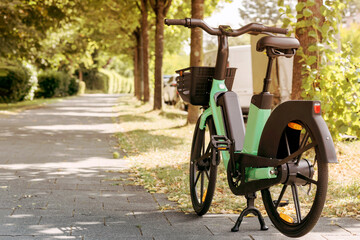 Bike or Electric Bicycle for Rental Service in Green City. Urban Electro bike charging battery in...