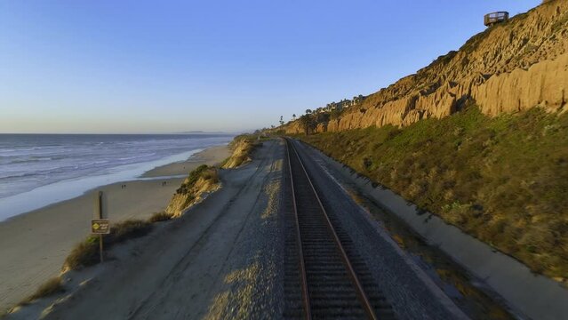 Aerial view tracking the Pacific Surfliner, scenic railway following the Californian Coast