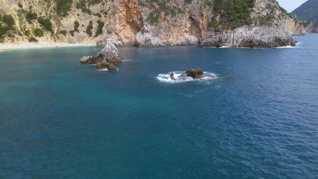 Aerial, low flight over sea water washing over rocks, Corfu, Greece, slow-motion