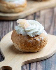Semla, fastelavnsbolle, fastlagsbulle. Decorated with an Estonian flag. On a wooden table with a dark background.