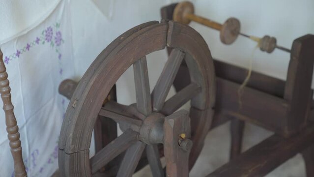 Old, vintage, antique spinning wheel in corner of old house. Close up parallax.