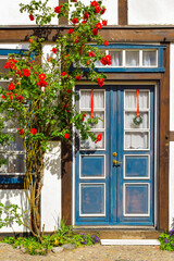 Fototapeta na wymiar Facade of old traditionaly Germany house, blue door, flowers. Rostock.