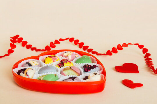 Valentine day composition: sweet candy, with gift boxes with bow and red felt hearts, photo template, background. Perspective View with copy space