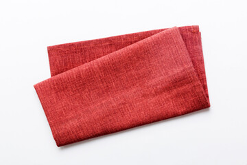 top view with red empty kitchen napkin isolated on table background. Folded cloth for mockup with...