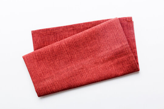 top view with red empty kitchen napkin isolated on table background. Folded cloth for mockup with copy space, Flat lay. Minimal style