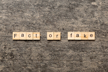 fact or fake word written on wood block. fact or fake text on table, concept