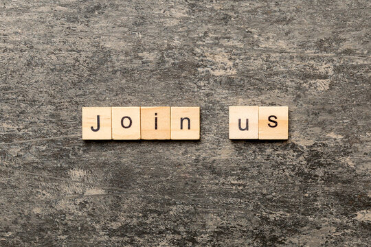 Join us word written on wood block. Join us text on cement table for your desing, Top view concept