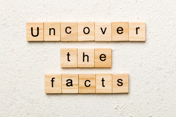uncover the fact word written on wood block. uncover the fact text on table, concept