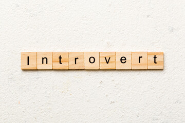 Introvert word written on wood block. Introvert text on table, concept