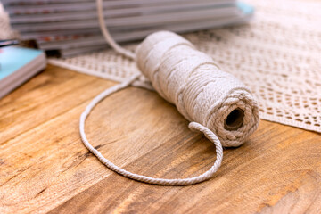Macrame. Handmade macrame braiding and cotton threads on wood background. Macrame mandala workshop