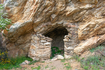shelter built with stones in a mountain hollow