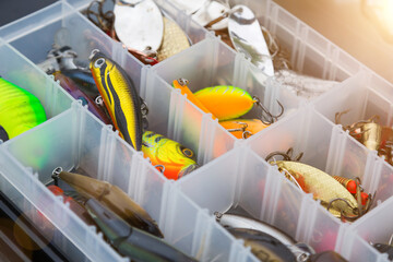 Fishing tackles and fishing baits in box .Classic Colored Fishing Lure , Beautiful Background digital image.Fishing on the lake at sunset. Fishing background