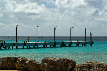 Obraz premium Wooden pier walkway on a beach with turquoise sea at Speightstown Barbados