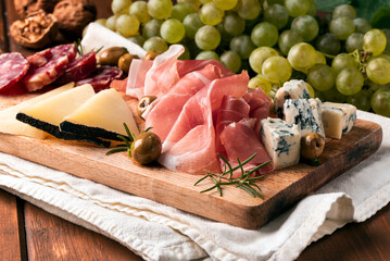 Tagliere di salumi e formaggi tipici italiani con sfondo di frutta fresca 