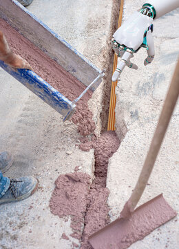 Filling with colored concrete of excavation with a narrow section for the implementation of a fiber optic distribution network for telecommunications.