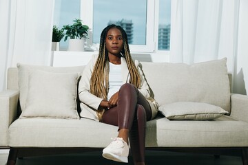 African american woman sitting with laptop on sofa at home freelancer business working, white...