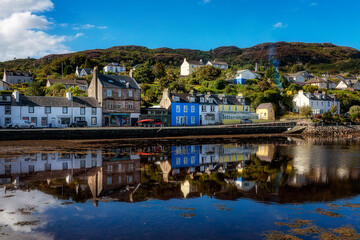 Reflections of houses in the harbour at Tarbert, Scotland, United Kingdom