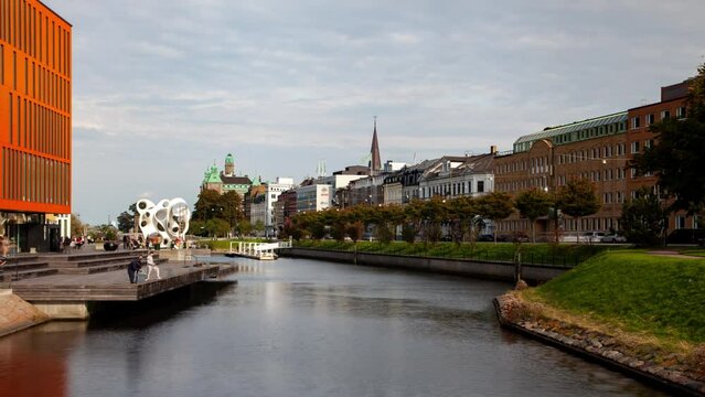 Malmo Downtown cityscape canal promenade with fast blurred traffic at daytime