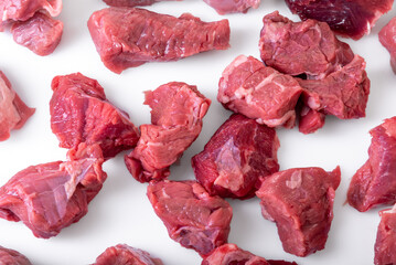 Raw beef diced for stew isolated on white , top view