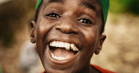 Close Up Portrait of an Expressive Authentic African Kid Smiling, Winking and Looking at the Camera...
