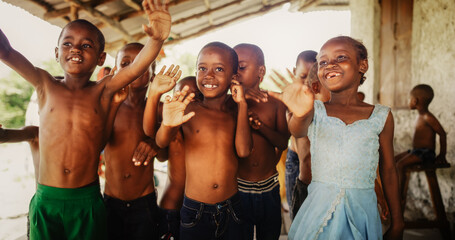 A Group Of African Children, Laughing, Jumping And Waving in Rural Area. Black Kids Celebrating...