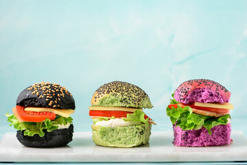 Fresh artisan baked burgers on pale blue background. Colorful modern concept in baking.