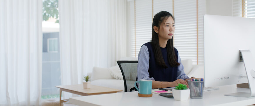 Young lady asia people teen girl talent workforce remote work at home office workspace sit relax on desk table. Distant job digital learn online reskill upskill career coding class chat on desktop PC.