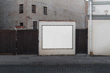 Blank billboard sign mockup in the urban environment, on the facade, empty space to display your...