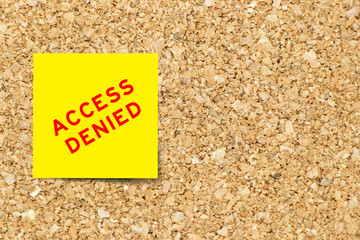 Yellow note paper with word access denied on cork board background with copy space
