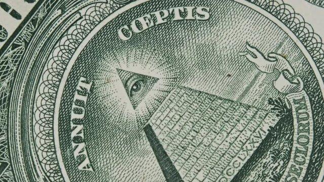 The all-seeing eye sign rotates on a one dollar bill close-up. Mason sign symbol. Concept inflation, economy, conspiracy. US banknote in macro with pyramid and mason eye. New world order, elite. 4K