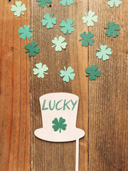 Flat lay with hat and clover on wooden table with lucky lettering