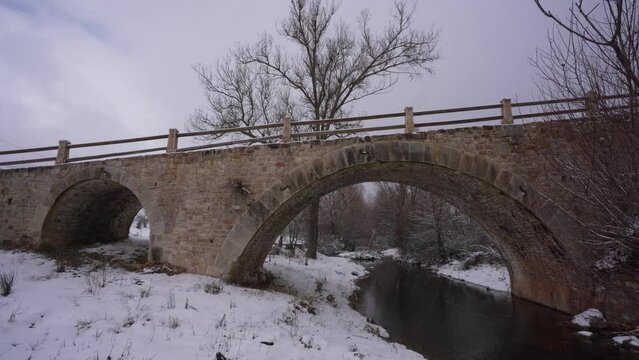 Beautiful old bridge built by stone from middle age on a winter snowy bacground in Albania