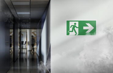 Fire exit sign in the corridor of the building with smoke. Emergency exit to right.