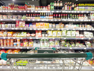 Abstract blurred supermarket.  choosing a dairy products at supermarket.empty grocery cart in an empty supermarket