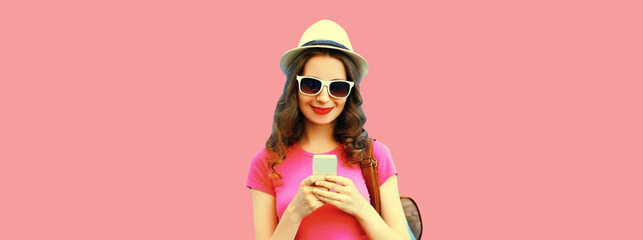 Portrait of happy smiling young woman tourist or student with smartphone wearing summer straw hat,...