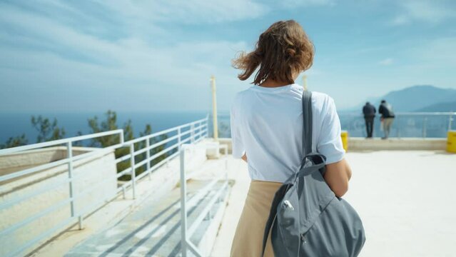 treking camera shot traveler freedom woman with backpack walking at view point on mountain top and enjoying mountains view, summer journey vacation. upper station of cable way in Antalya, Turkey