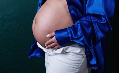 portrait of pregnant caucasian woman holding her hands on baby bump.